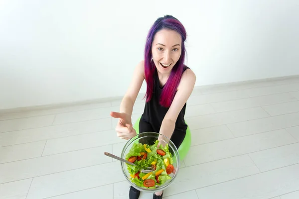 Vue du dessus d'une jeune fille hipster asiatique qui mange une salade de légumes légers après une séance d'entraînement chez elle. Concept de perte de poids et mode de vie sain . — Photo
