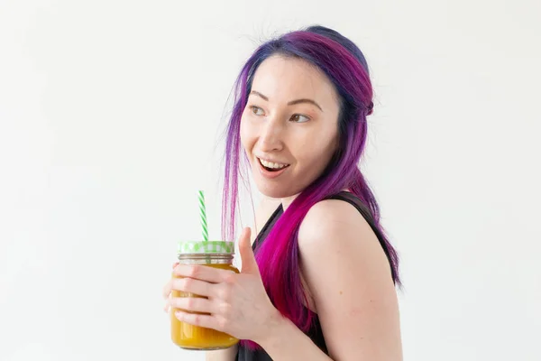 Retrato de uma jovem mista positiva e menina hipster com cabelo colorido segurando smoothie proteína de frutas em um fundo branco. Conceito de estilo de vida saudável — Fotografia de Stock