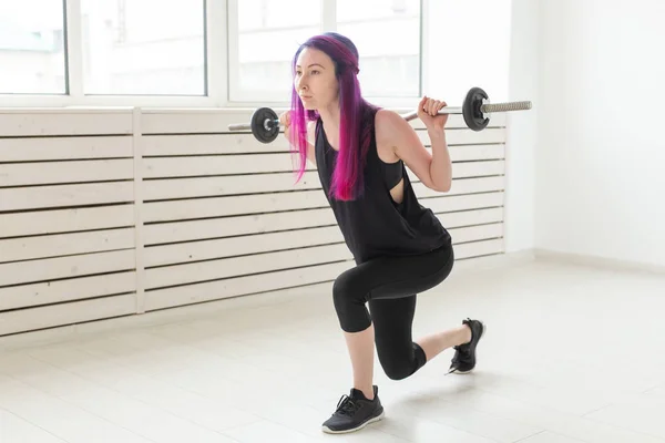 Fitness, deporte, concepto de personas - mujer joven en traje deportivo está en cuclillas con bar —  Fotos de Stock