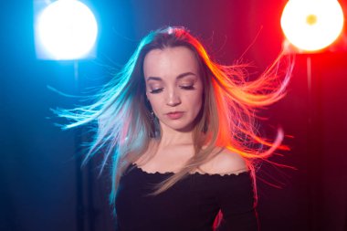 Gece kulübü, gece hayatı ve insan konsepti-karanlıkta poz veren genç kadın