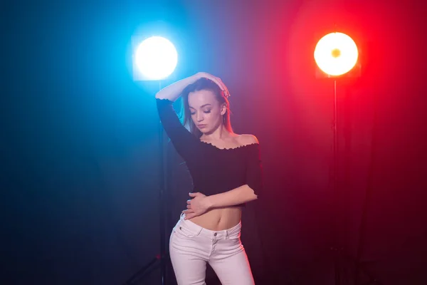 Concepto de danza, gracia y elegancia: mujer joven bailando el estilo de dama bachata en la oscuridad, luces y humo —  Fotos de Stock