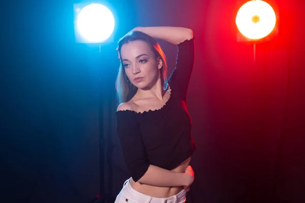 Tanz- und People-Konzept - junge sexy Frau tanzt im Dunkeln und genießt es — Stockfoto