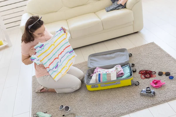 Yaz tatilleri, yolculuk ve gezgin kavramı - Genç güzel kadın bir yaz seyahatbir bavul toplar