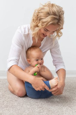 Aile, çocuk ve ebeveyn kavramı - mutlu gülümseyen genç anne evde küçük bebekle oynarken