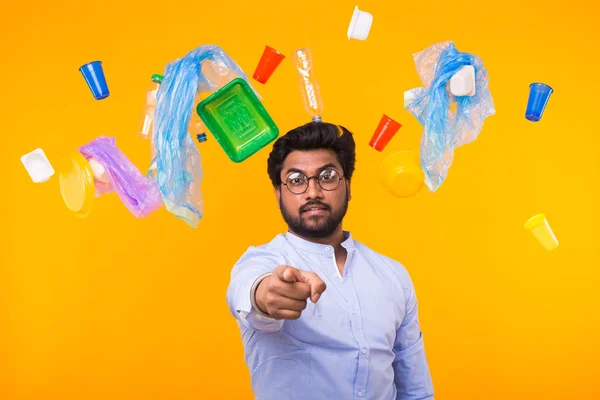 Problema de reciclaje de plástico, ecología y concepto de desastre ambiental - Hombre indio apuntar sobre usted en el fondo amarillo — Foto de Stock