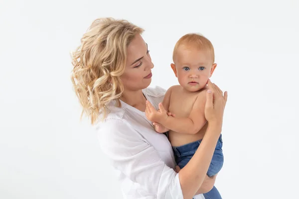 Conceito de família, maternidade e família - Mãe jovem segurando seu bebê em fundo branco — Fotografia de Stock