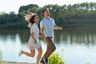 Yaz doğa, ilişki ve aşk kavramı insanlar - mutlu çift göl yakınında çalışan