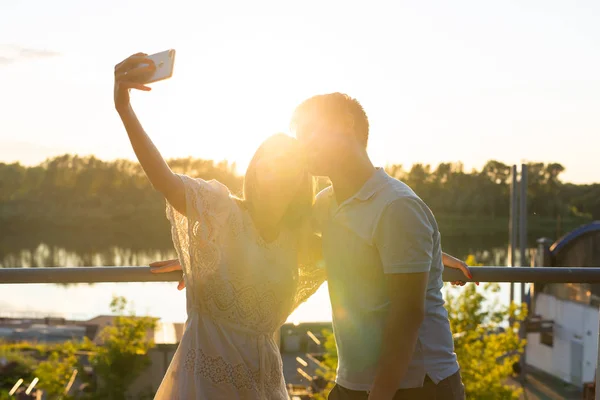 Lichtblicke einfangen. freudiges junges lustiges Liebespaar macht Selfie vor der Kamera im Freien — Stockfoto