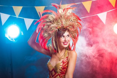 Karnaval, oryantal dans ve tatil konsepti - Altın kostüm giyen ve gülümseyen güzel kadın samba dansçısı