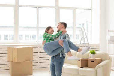 Yeni evlerine taşınırken sevinç kucaklayan genç çift Loving. Genç ailenin hareketli ve ev ısınması kavramı.