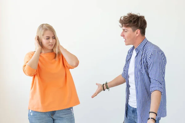 Young hipster guy shouts raising his hands up to his beloved girl on a white background. Concept of bad relationships and family breakdown. — Stock Photo, Image