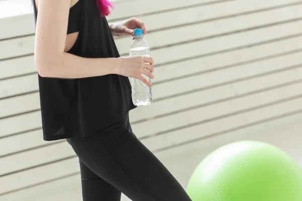 Primer plano de la mujer asiática sosteniendo el agua después del entrenamiento de gimnasio. Concepto de reponer el equilibrio hídrico y un estilo de vida saludable . — Foto de Stock