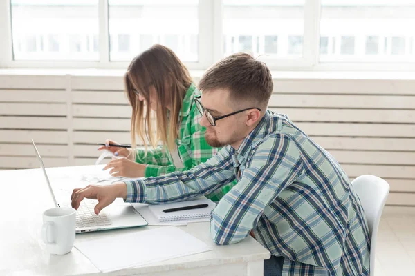 Genç karı koca bir dizüstü bilgisayar ile masada otururken ödemeler ve onarım için satın alma için çok sayıda çek ler hakkında üzgün. Düşük yaşam standartları ve tasarruf kavramı.