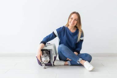 Pozitif iyi görünümlü kadın ve güzel gri İskoç Fold kedi hareketten sonra onu yeni daire içine. Housewarming ve evcil hayvan kavramı.