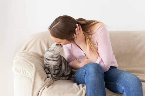 집에서 여자는 그녀의 사랑스러운 푹신한 고양이 키스. 회색 태비 귀여운 스코틀랜드 접이식 고양이입니다. 애완 동물과 라이프 스타일 개념. — 스톡 사진