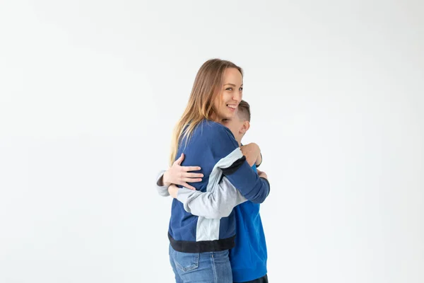 Conceito de pai, família e pai solteiro - Uma mãe feliz e filho adolescente rindo e abraçando em fundo branco com espaço de cópia — Fotografia de Stock