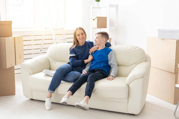 Jonge schattige alleenstaande moeder en zoon zijn blij met de verhuizing naar een nieuw huis. Concept van Inwijdingsfeest en familie ruimte-uitbreidingen. — Stockfoto