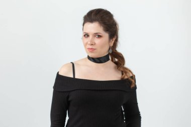 Beyaz bir arka plan üzerinde poz boyun siyah kurdele ile güzel bir romantik genç kadının portresi. Güzellik konsepti