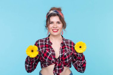 Yaz, pin-up ve eğlenceli kavram - mavi arka plan üzerinde gerberas ile güzel kadın
