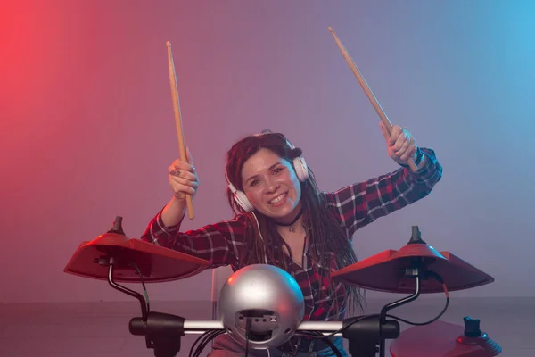 Music, electronic drum set and hobby concept - woman drummer in a recording studio