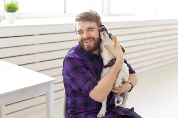 Animal, pet and people concept - Attractive cheerful man in plaid shirt holds favourite pet