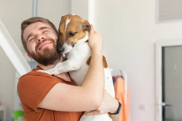 Animal, pet and people concept - Smiling man in casual mustard t-shirt with his jack russell terrier — Stock Photo, Image