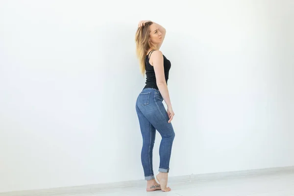 Estilo, conceito de pessoas - jovem mulher de jeans e camisa preta em pé sobre o fundo branco com espaço de cópia — Fotografia de Stock