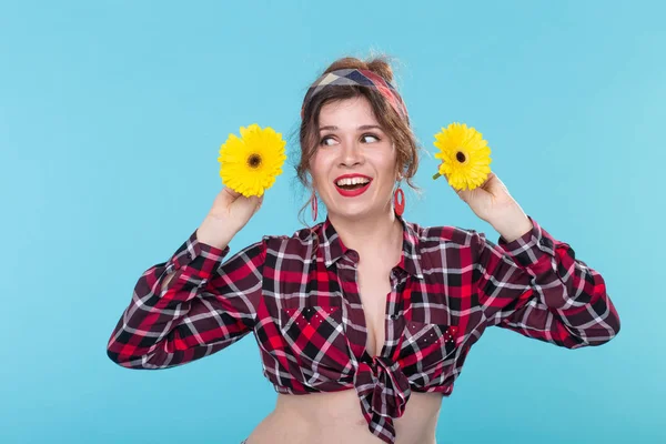 mavi arka plan üzerinde iki gerberas ile pin-up kadın