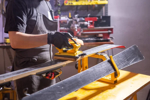 Close-up van de jonge man repareren van de ski in de service — Stockfoto