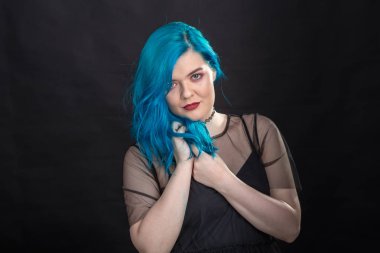 Stil ve moda konsepti - Siyah arka plan üzerinde poz mavi saçlı genç ve çekici kadın