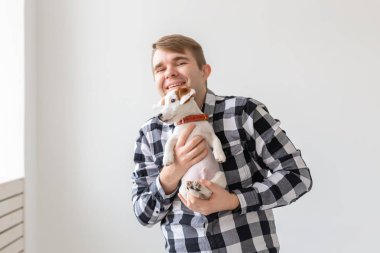 insanlar, Evcil hayvanlar ve hayvanlar kavramı - yakışıklı adam tutarak jack russell terrier yavru beyaz arka plan üzerinde