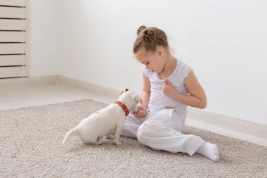 Çocuk ve hayvan kavramı - kız çocuk ve köpek yavrusu katta oturan pijama giymiş