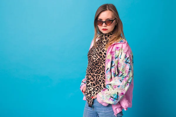 Conceito de look de moda vintage - mulher muito jovem vestindo uma jaqueta rosa retro e corpo de leopardo no fundo azul com espaço de cópia — Fotografia de Stock