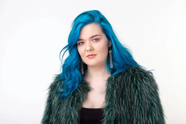 Proteção animal, moda e conceito de cabelo - menina bonita vestida com casaco de pele artificial com cabelo azul em pé sobre fundo branco — Fotografia de Stock