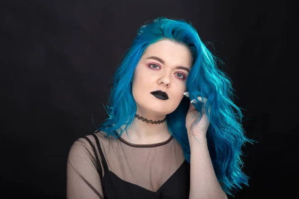 Lidé, móda a vlasový koncept-blízký portrét mladé ženy v černých šatech s modrými vlasy na černém pozadí — Stock fotografie