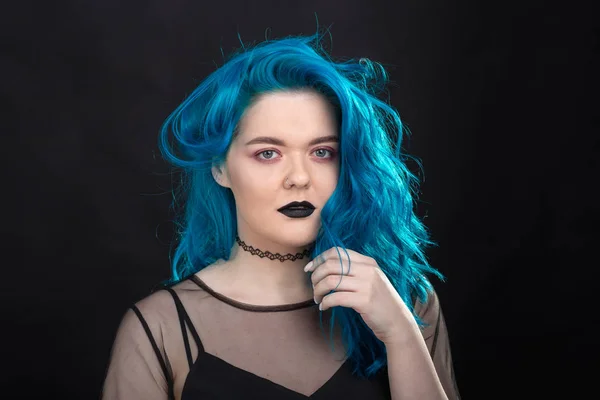 Gente y concepto de moda - Mujer joven y atractiva con lápiz labial negro y pelo azul posando sobre fondo negro — Foto de Stock