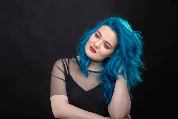 People, fashion and hair concept - close-up portrait of young woman in black dress with blue hair on black background — Stock Photo, Image