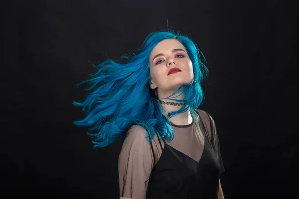 Pessoas e conceito de moda - Mulher jovem e atraente com batom preto e cabelo azul posando sobre fundo preto — Fotografia de Stock