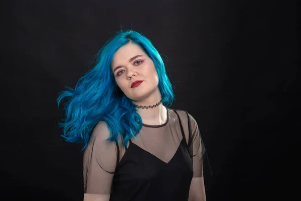Koncepce lidí a módy-mladá a přitažlivá žena s černou rtěnky a modrými vlasy na černém pozadí — Stock fotografie