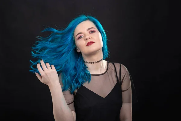 Pessoas, moda e conceito de cabelo - close-up retrato de jovem mulher em vestido preto com cabelo azul no fundo preto — Fotografia de Stock