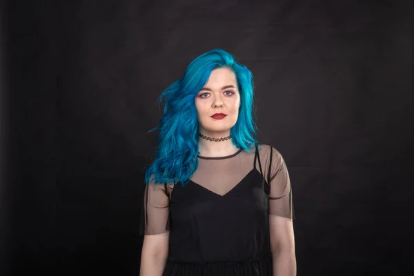 Estilo, moda e conceito de cabelo - close-up retrato de jovem mulher em vestido preto com cabelo azul no fundo preto — Fotografia de Stock