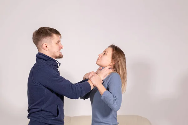 Mensen, huiselijk geweld en misbruik concept-jonge man verstikte zijn vrouw op witte achtergrond — Stockfoto