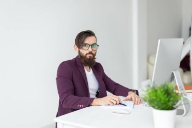 İnsan ve teknoloji kavramı - adam oturur ve bilgisayarda çalışır