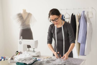 Terzi, moda tasarımcısı ve terzi kavramı - genç kadın Tasarımcısı hafif kumaş keser