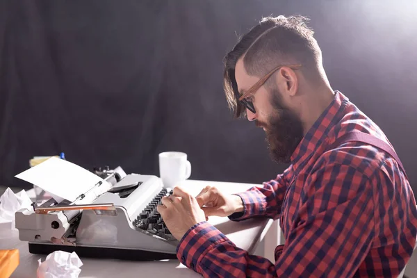 Άνθρωποι και τεχνολογία έννοια - παγκόσμια ημέρα κατά του συγγραφέα, όμορφος άντρας με γυαλιά, ντυμένοι με καρό πουκάμισο, εργάζονται σε γραφομηχανή — Φωτογραφία Αρχείου