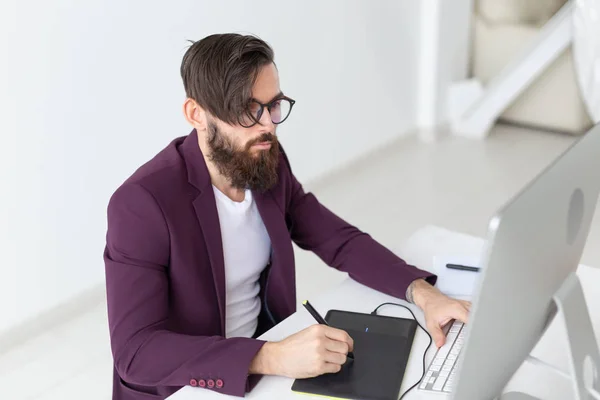 Ludzi i technologii koncepcja - atrakcyjne człowieka z brodą, ubrany w purpurowe kurtka pracy na komputerze — Zdjęcie stockowe