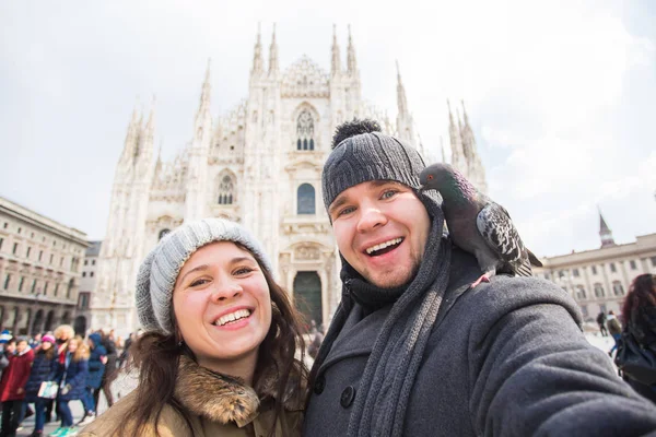 Milano Duomo Meydanı'nda güvercin ile kendi kendine portre çekici çift. Kış seyahat, İtalya ve ilişki kavramı