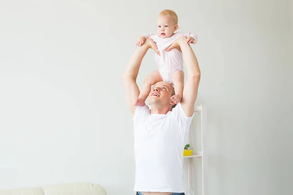 Concepto de paternidad y familia - Padre y bebé pequeño en el interior de casa, jugando . — Foto de Stock