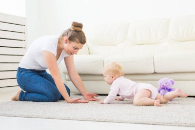 Sevimli bebek kız beyaz güneşli odada sürünmek öğrenme.