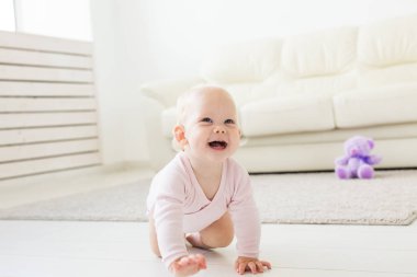 güzel gülümseyen bebek ilk kez sürünerek.